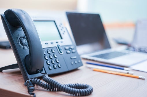 Telephone and Laptop Devices Kept at an Office Desk