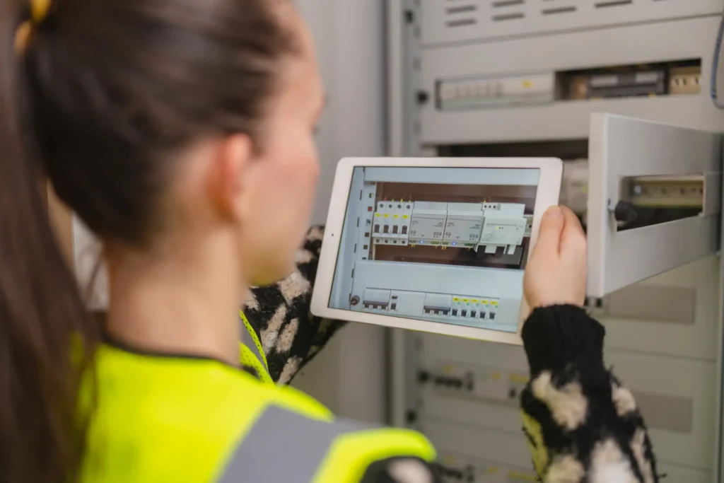 Technician inspecting an electrical panel using a tablet during property maintenance in San Jose, CA
